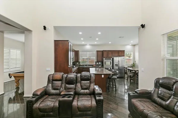 a living room with furniture kitchen area and a window