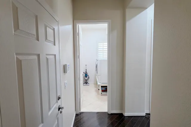 a view of a hallway with wooden floor and closet