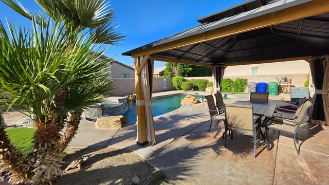 a view of a patio with table and chairs floor to ceiling window with wooden floor and outdoor seating