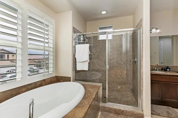 a bathroom with a granite countertop tub shower and sink