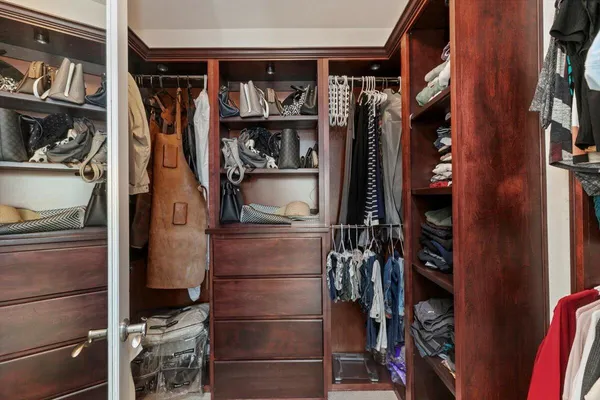 a view of walk in closet with clothes and shoes