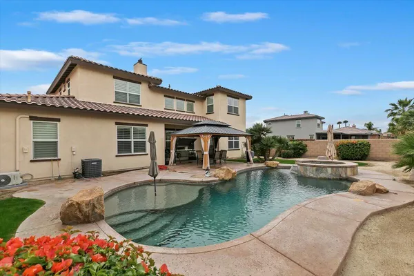 a view of a house with pool and chairs