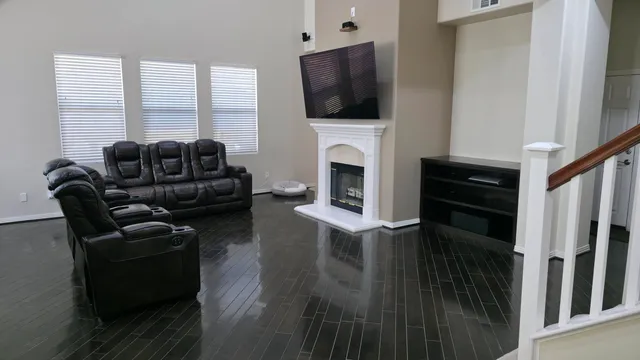 a living room with furniture a flat screen tv and a fireplace