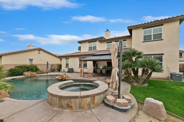 a view of a house with backyard sitting area and swimming pool