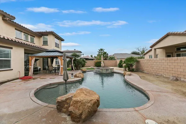 a view of a house with swimming pool and sitting area