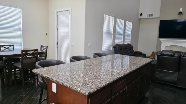 a kitchen with granite countertop kitchen island sink table and chairs
