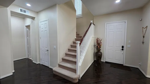 a view of a hallway with wooden floor and staircase
