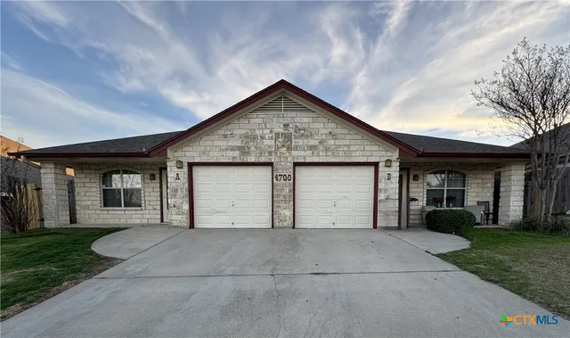 a front view of a house with yard and garage