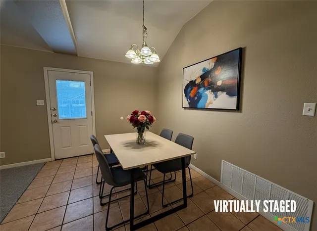 a view of a dining room with furniture and chandelier