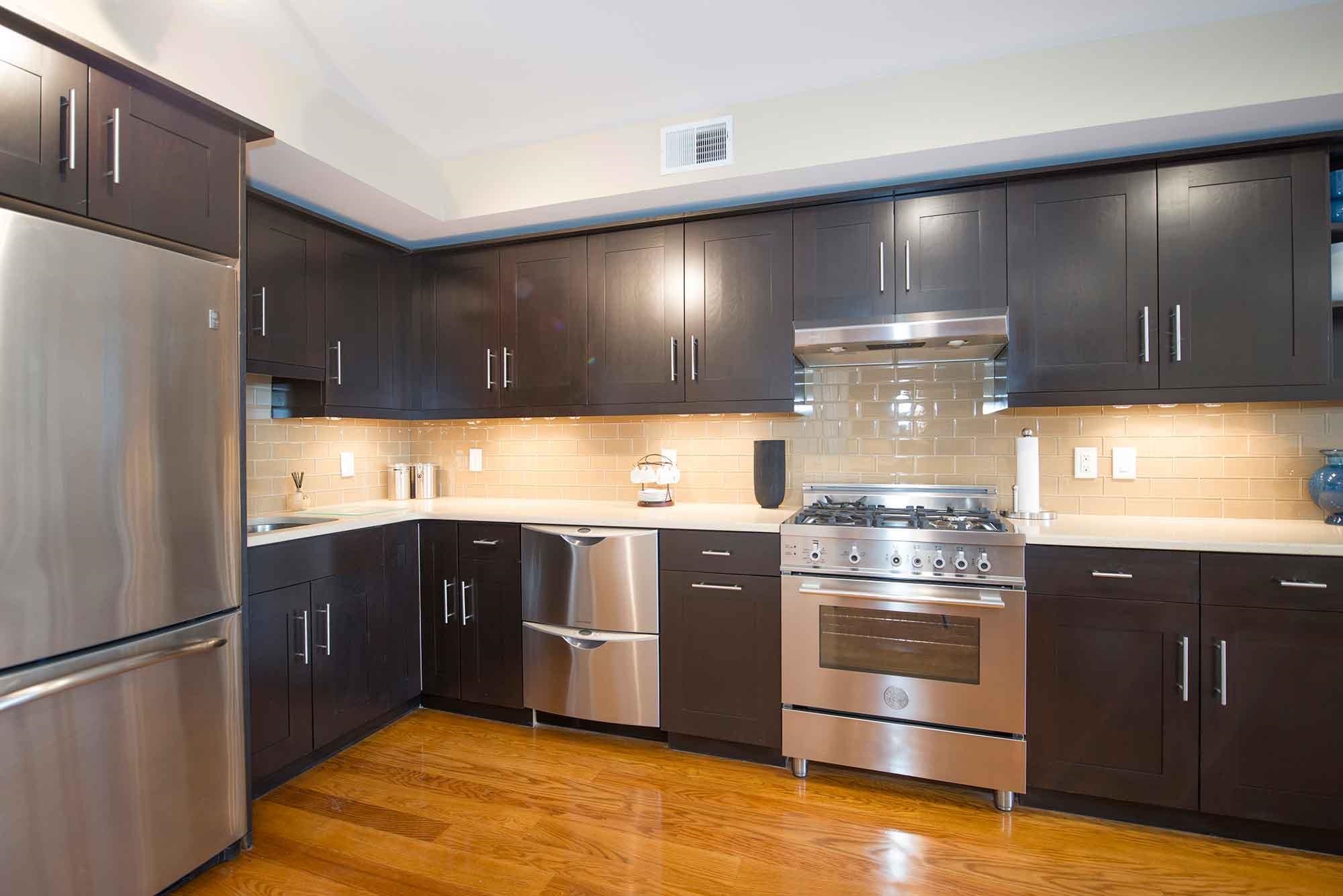 a kitchen with stainless steel appliances granite countertop a refrigerator and a stove