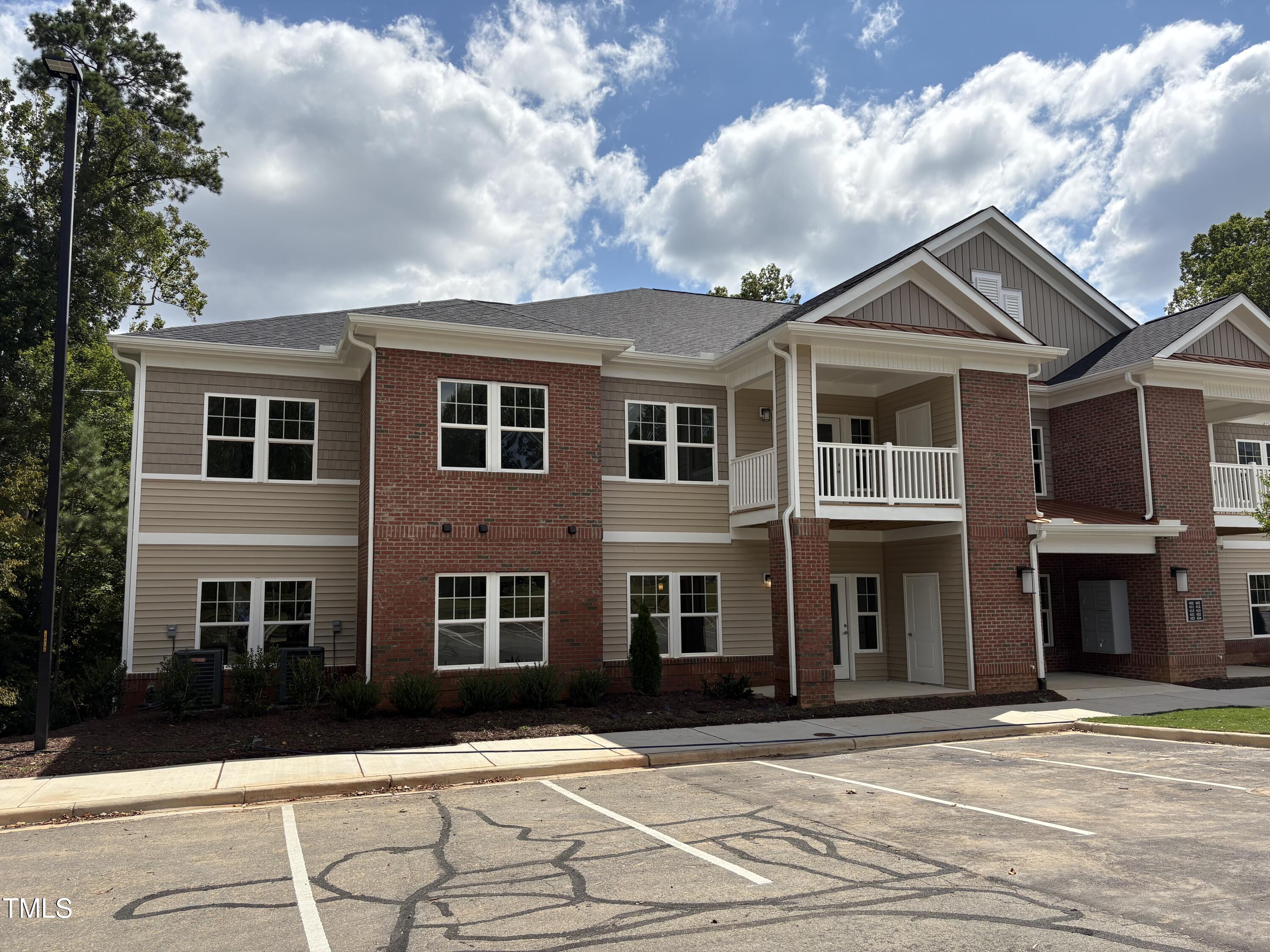 621 Weather Ridge Lane, Unit 33 Cary, NC 27513 - Photo 16 of 20 a view of a brick house with many windows and a yard