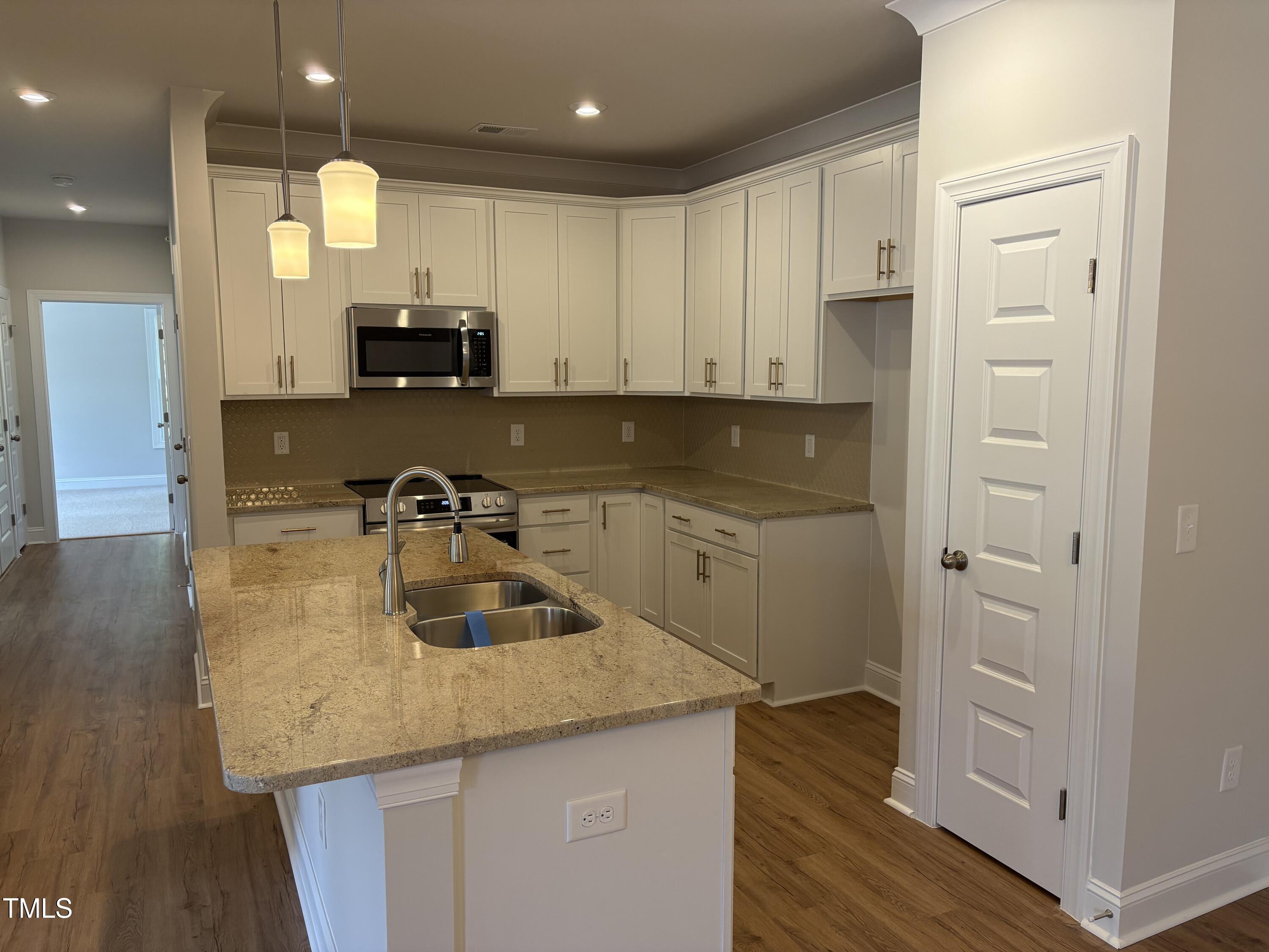 621 Weather Ridge Lane, Unit 33 Cary, NC 27513 - Photo 4 of 20 a kitchen with a sink a stove and cabinets