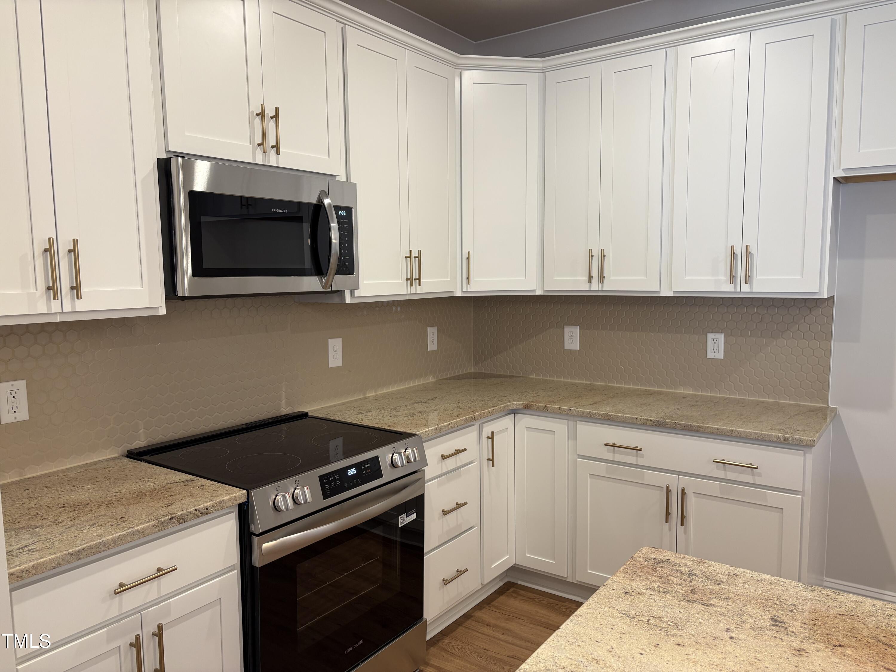 621 Weather Ridge Lane, Unit 33 Cary, NC 27513 - Photo 6 of 20 a kitchen with granite countertop white cabinets and stainless steel appliances