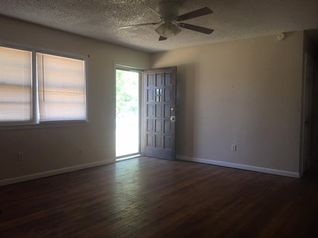 523 55th Street Lubbock, TX 79404 - Photo 3 of 9 an empty room with wooden floor and windows