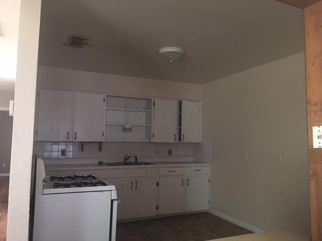 523 55th Street Lubbock, TX 79404 - Photo 5 of 9 a kitchen with granite countertop white cabinets and white appliances