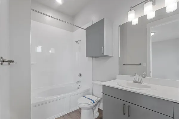 a bathroom with a sink a toilet a mirror and shower