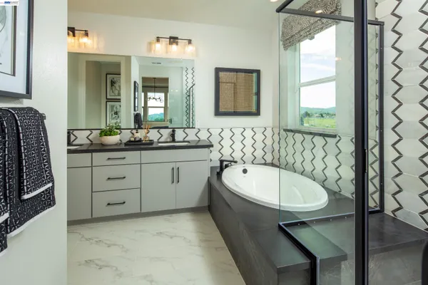 a bathroom with a double vanity sink a mirror and a bathtub