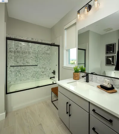 a bathroom with a granite countertop sink a large mirror and a shower