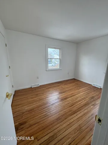 a view of room with wooden floor and window