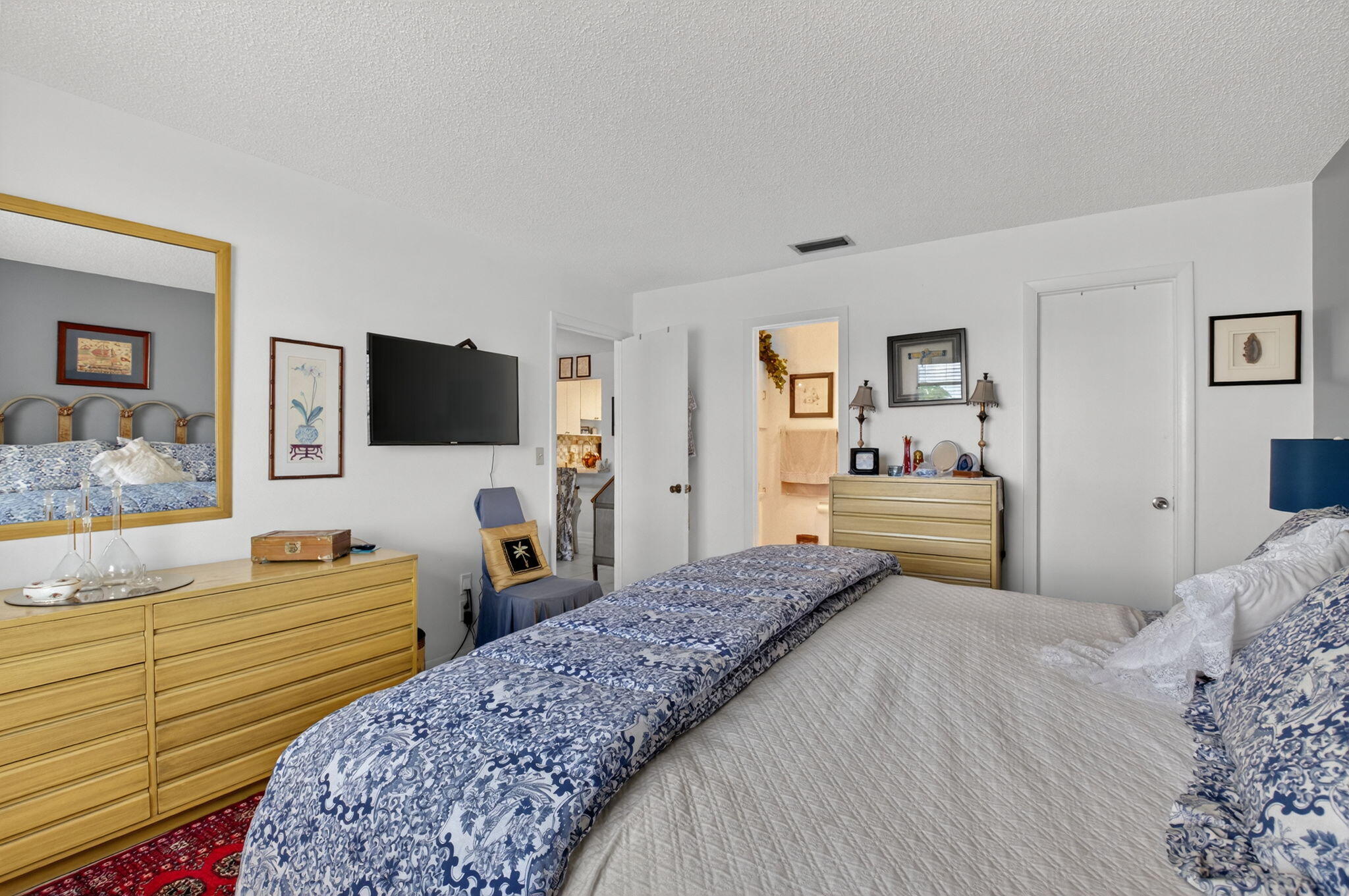 13757 Flora Place, Unit G Delray Beach, FL 33484 - Photo 15 of 58 a bedroom with a bed and a flat screen tv