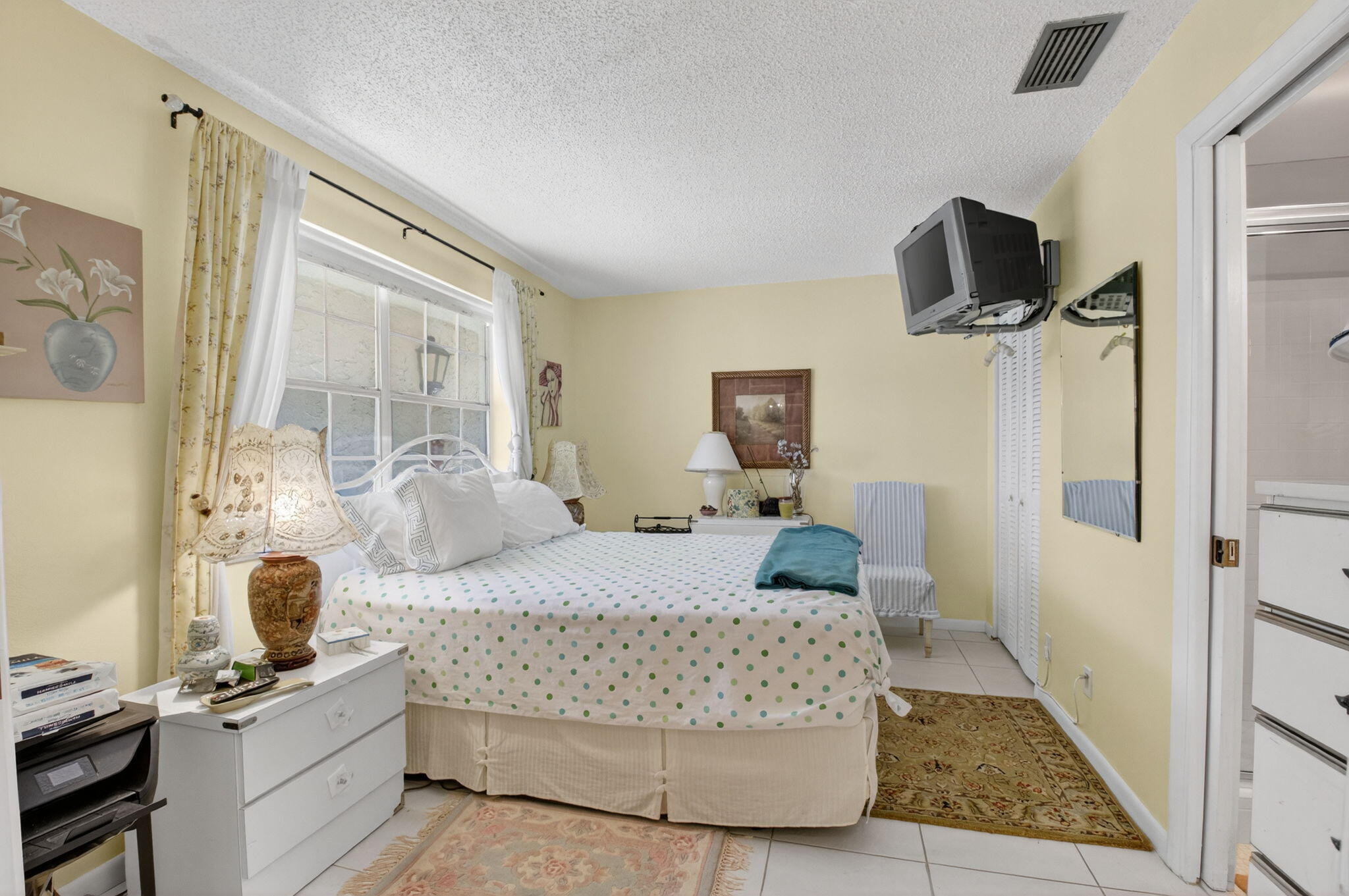13757 Flora Place, Unit G Delray Beach, FL 33484 - Photo 19 of 58 a bedroom with a bed and a flat screen tv