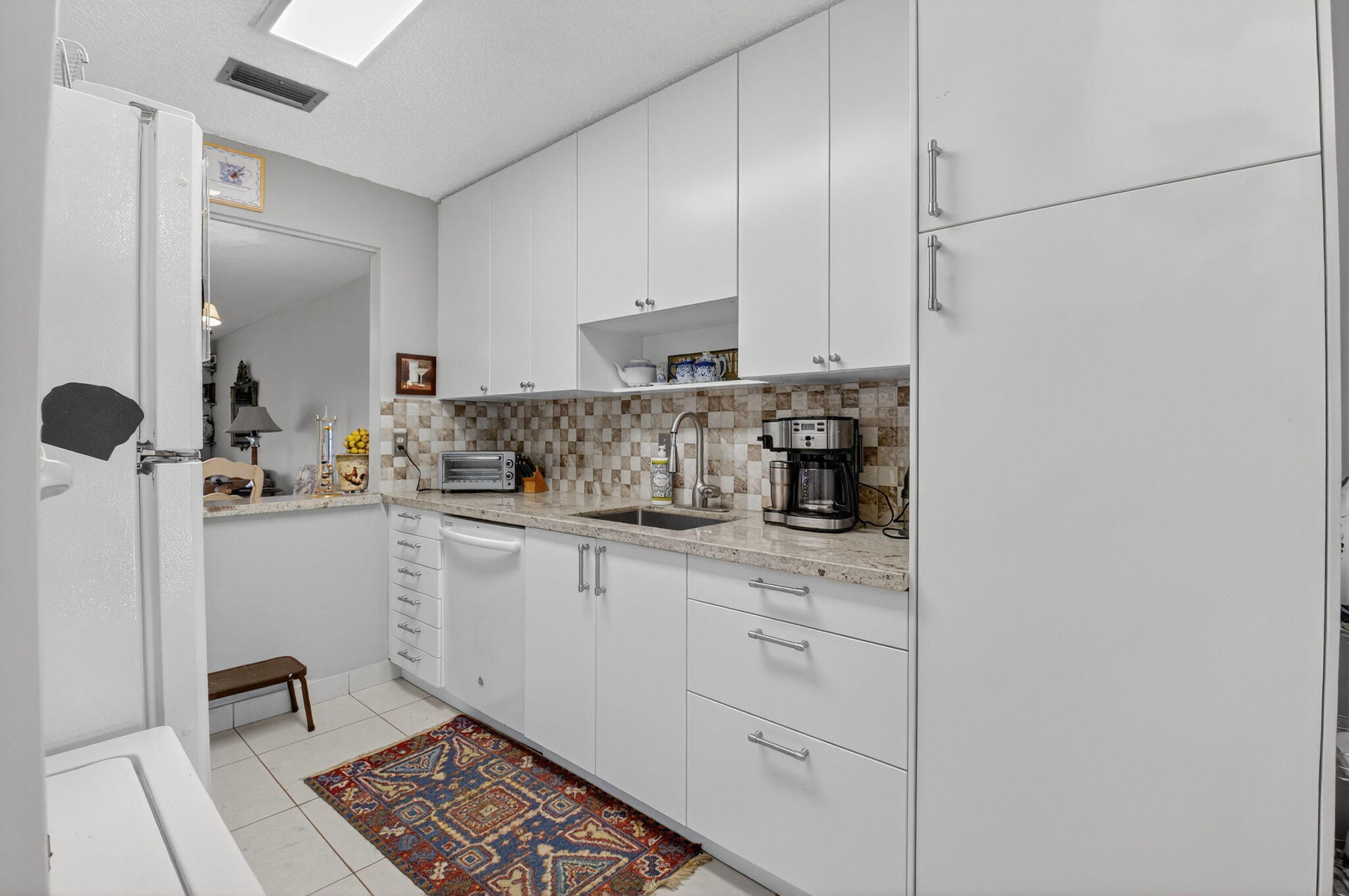 13757 Flora Place, Unit G Delray Beach, FL 33484 - Photo 4 of 58 a kitchen with a sink and cabinets