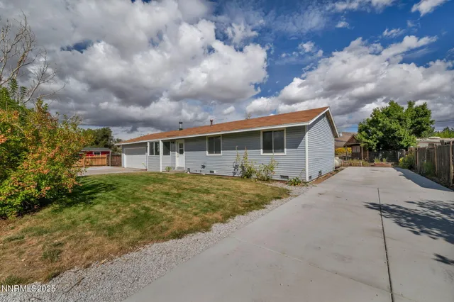 a front view of house with yard and trees around