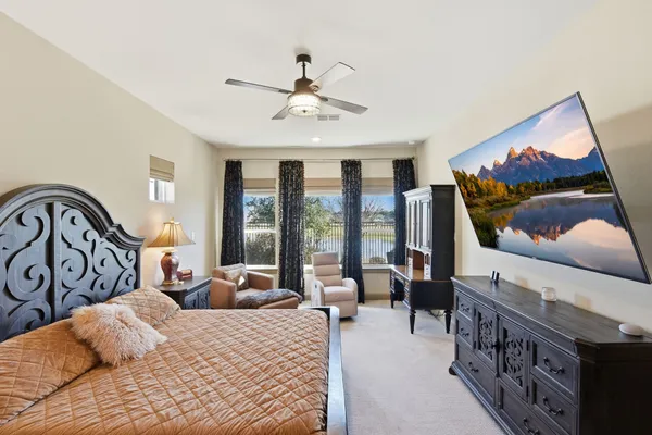 a bedroom with a bed a couch and a large window