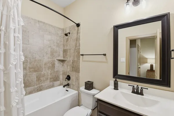 a bathroom with a granite countertop sink mirror toilet and bathtub