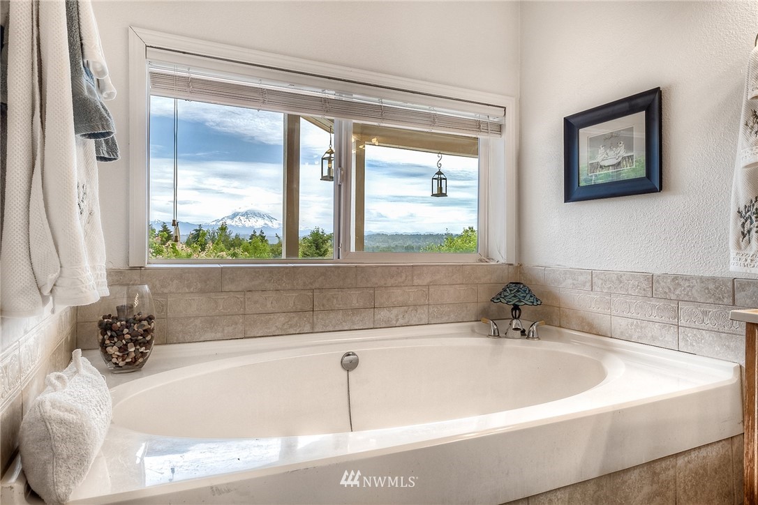 11112 Karshner Road East Edgewood, WA 98372 - Photo 19 of 40 a white bath tub sitting in a bathroom next to a window