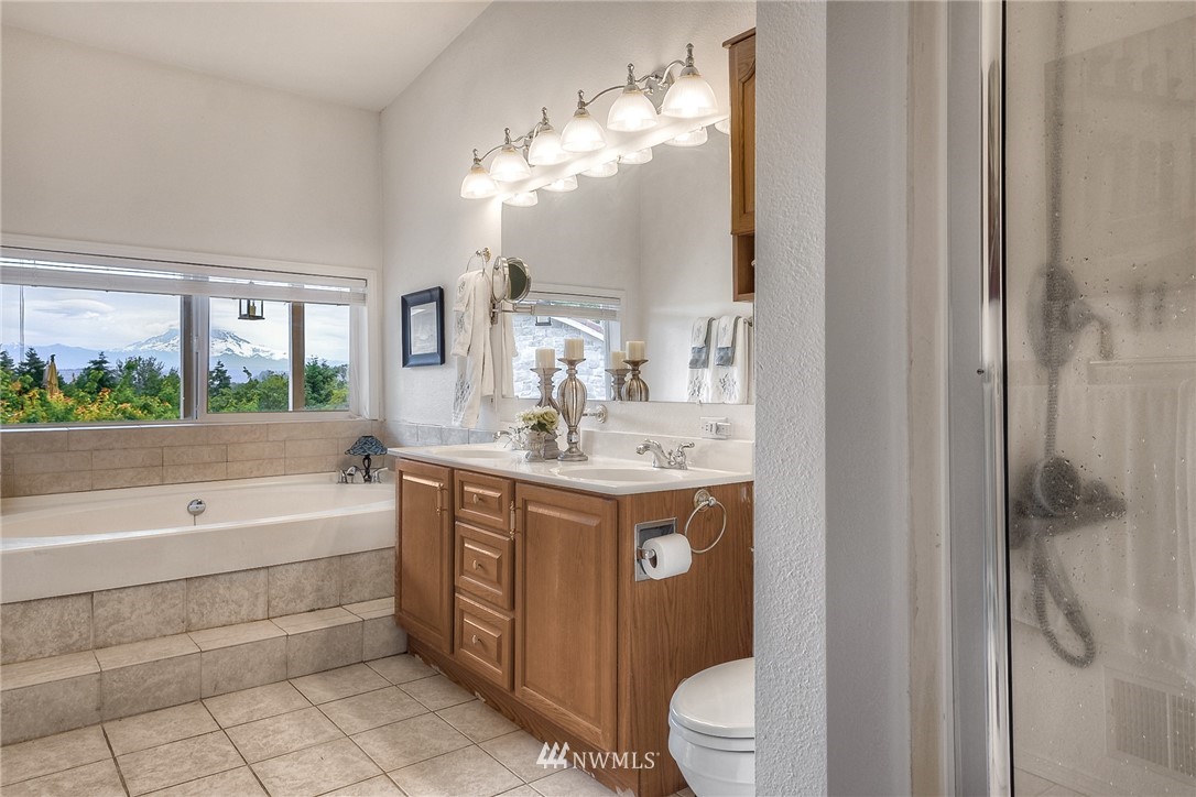 11112 Karshner Road East Edgewood, WA 98372 - Photo 20 of 40 a bathroom with a granite countertop sink a toilet and bathtub