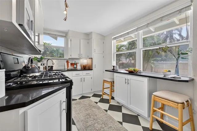 a kitchen with a stove a sink and a granite counter top