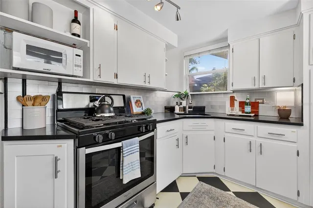 a kitchen with stainless steel appliances granite countertop a stove a sink and cabinets