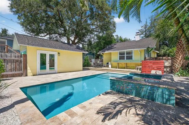a view of a house with pool and chairs