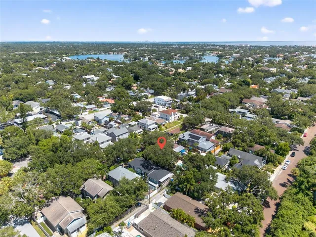 an aerial view of residential houses with outdoor space and trees