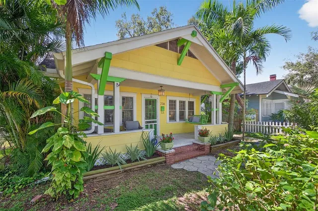 a view of a house with a small yard and sitting area