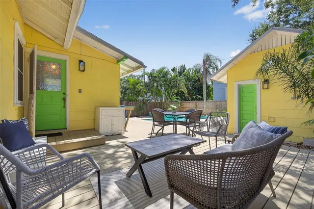 a view of a patio with couches and table and chairs and potted plants