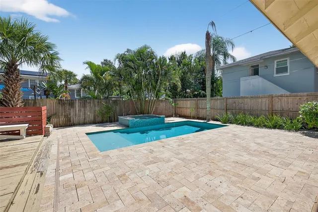 a view of backyard with table and chairs a wooden fence and plants