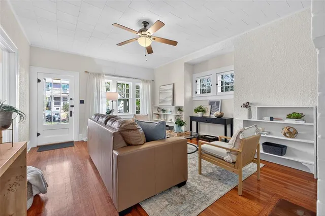 a living room with furniture and a wooden floor