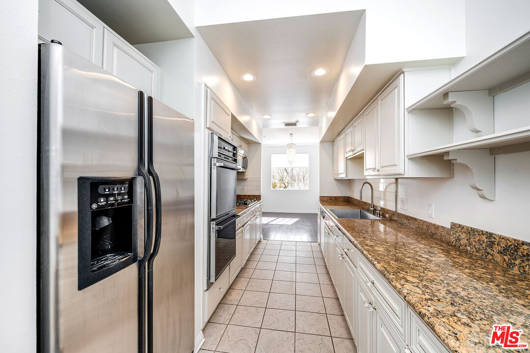 10630 Eastborne Avenue, Unit 203 Los Angeles, CA 90024 - Photo 11 of 26 a kitchen with stainless steel appliances granite countertop a refrigerator and a sink
