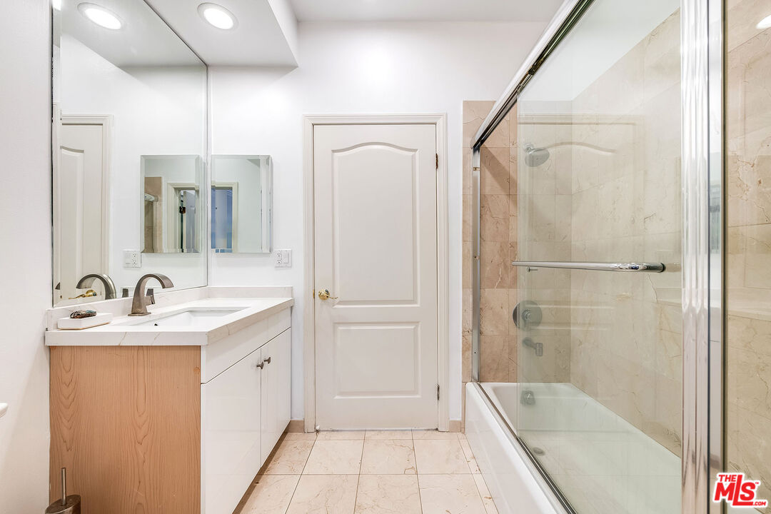 10630 Eastborne Avenue, Unit 203 Los Angeles, CA 90024 - Photo 19 of 26 a bathroom with a bathtub a shower a sink and mirror