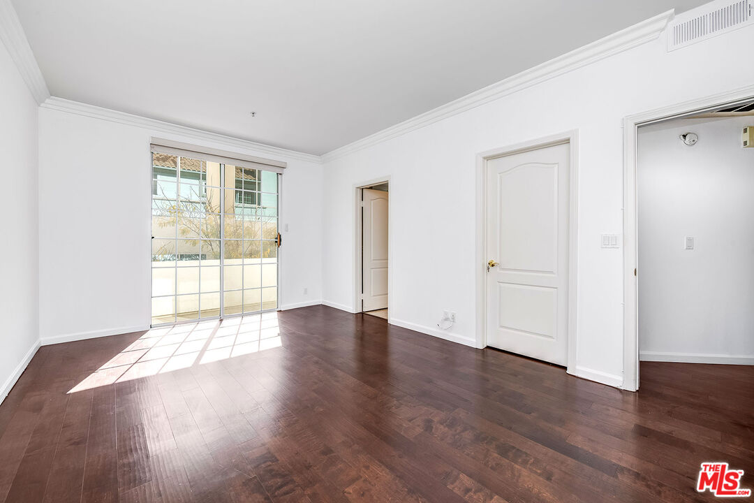 10630 Eastborne Avenue, Unit 203 Los Angeles, CA 90024 - Photo 20 of 26 an empty room with wooden floor and windows