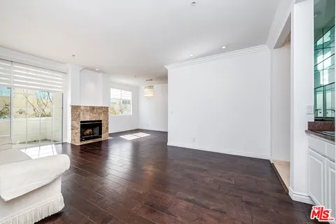 a view of a livingroom with wooden floor and a fireplace
