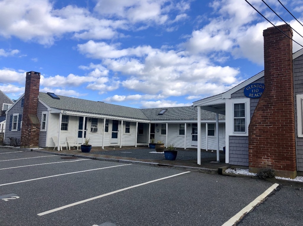 110 Glendon Road, Unit 9 Dennis, MA 02639 - Photo 5 of 22 a front view of a building with lot of cars and trees