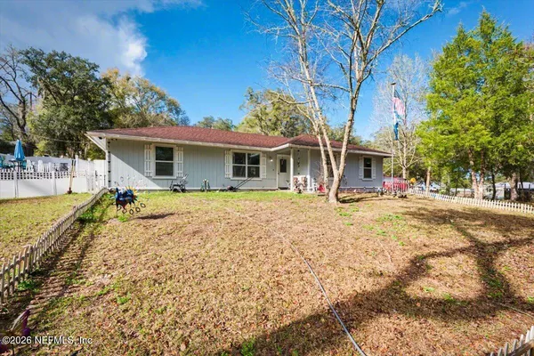 a front view of house with yard and trees around