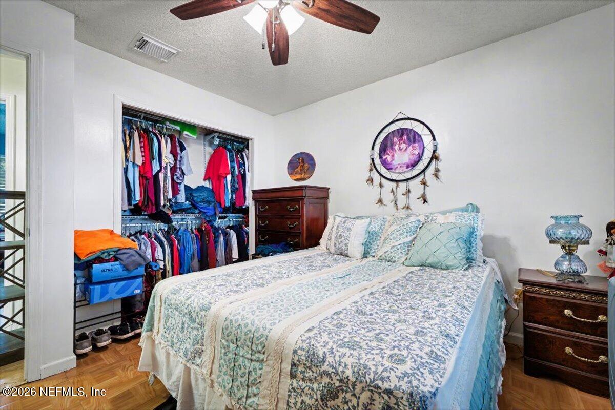 53 Lion Street Middleburg, FL 32068 - Photo 13 of 28 a bedroom with a bed and a chandelier