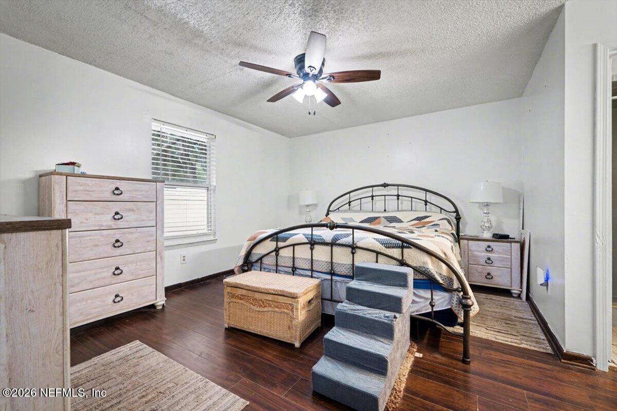 53 Lion Street Middleburg, FL 32068 - Photo 14 of 28 a bedroom with a bed and a chandelier
