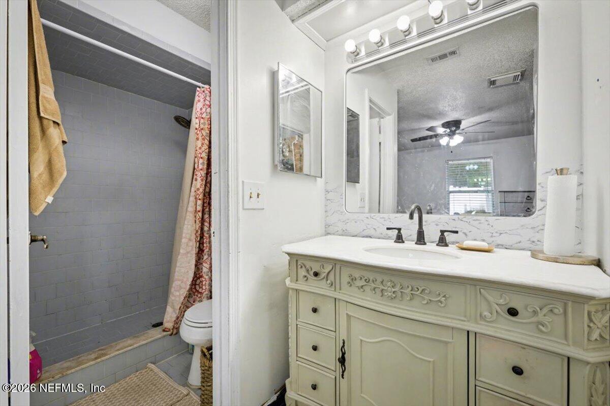 53 Lion Street Middleburg, FL 32068 - Photo 15 of 28 a bathroom with a granite countertop sink mirror and a toilet