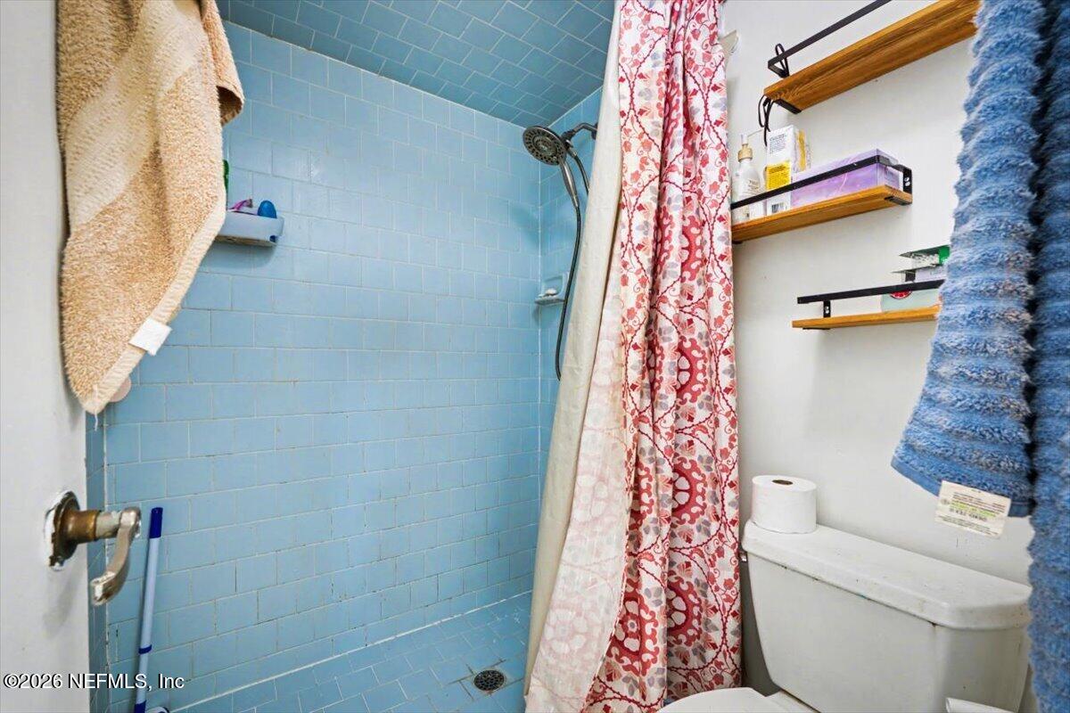 53 Lion Street Middleburg, FL 32068 - Photo 16 of 28 a bathroom with a toilet and a shower curtain