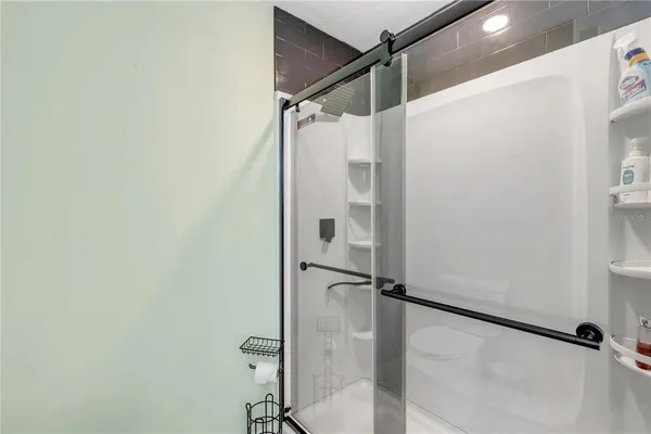 a bathroom with a shower and a glass door